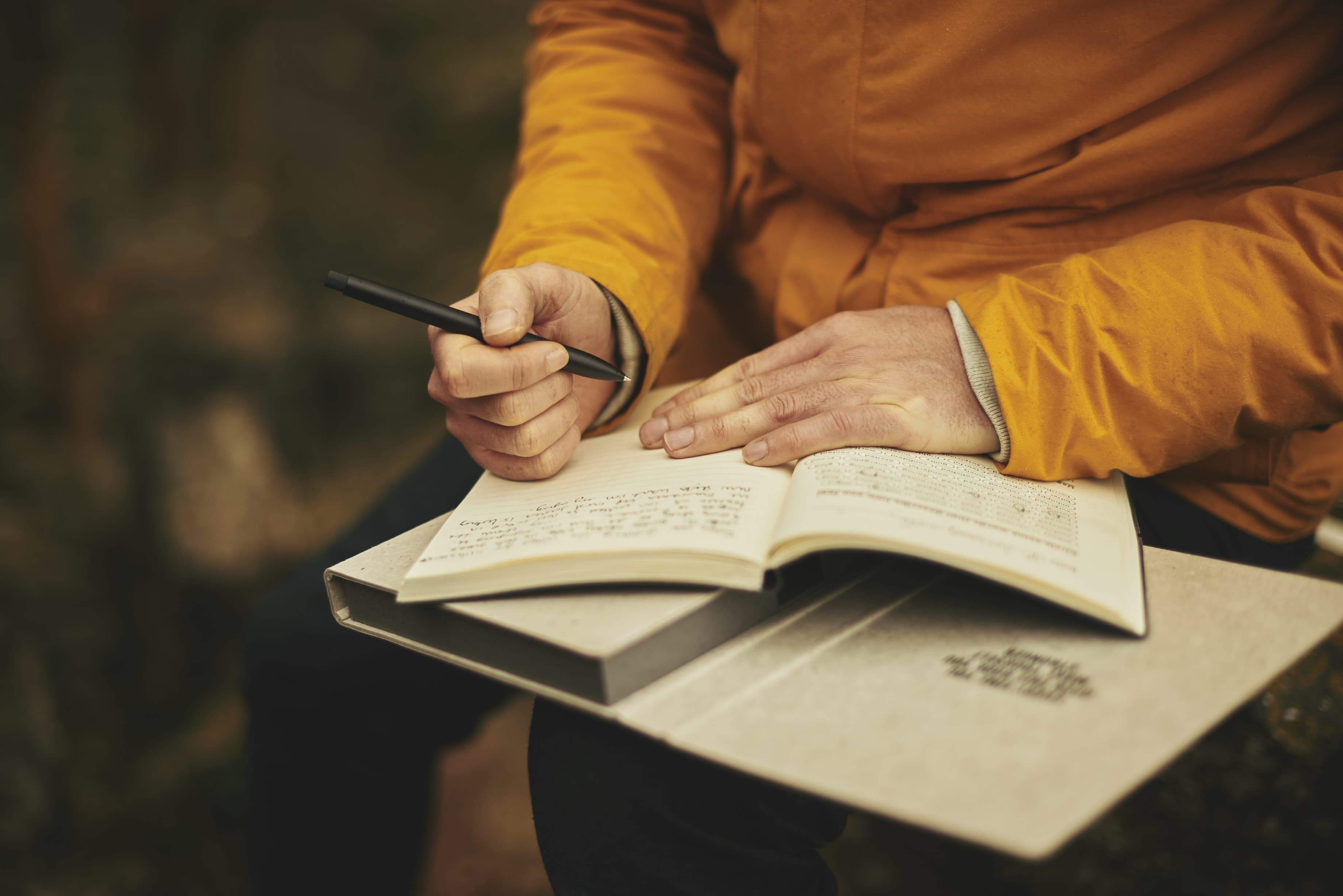 Hands writing in a journal